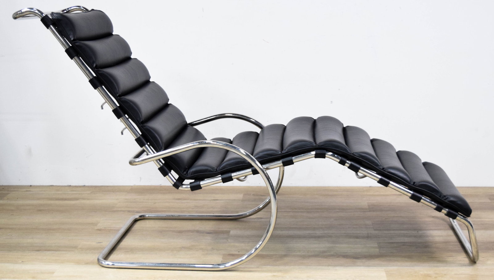 Mies Van Der Rohe Style Adjustable Lounge Chair: Mid-Century Modern adjustable cantilevered lounge chair with integrated armrests in the style of Ludwig Mies van der Rohe. Black leather upholstery on a chrome-plated steel frame. Backrest incorporate