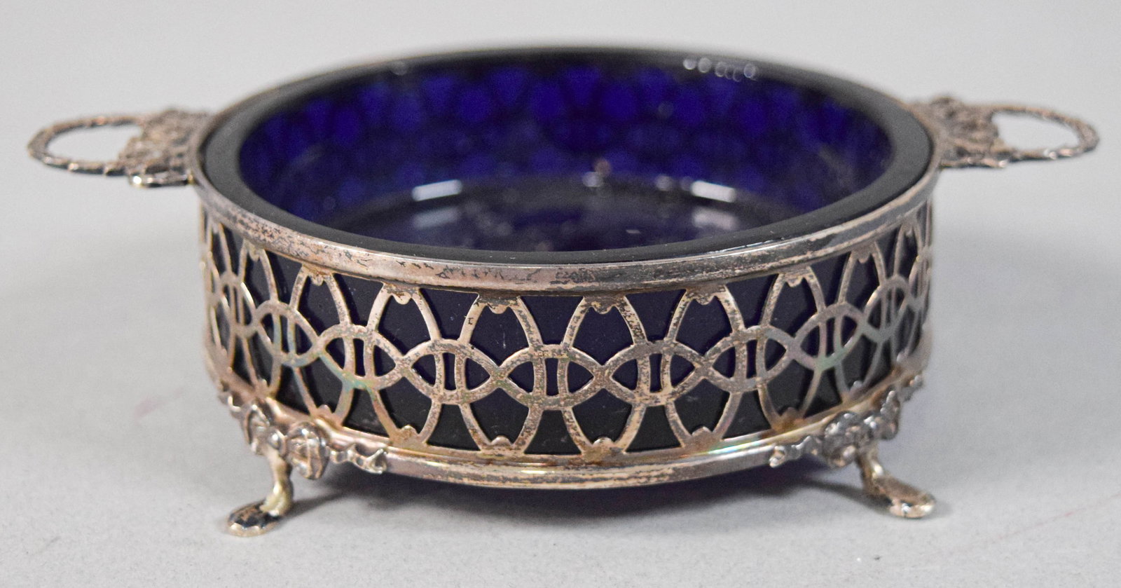 Docker & Burn Sterling Silver and Glass Footed Dish, 1894: Docker & Burn sterling silver openwork frame with a cobalt blue glass liner on four feet. Underside of the sterling rim with several hallmarks: D&B, Birmingham anchor, lion passant, and date l