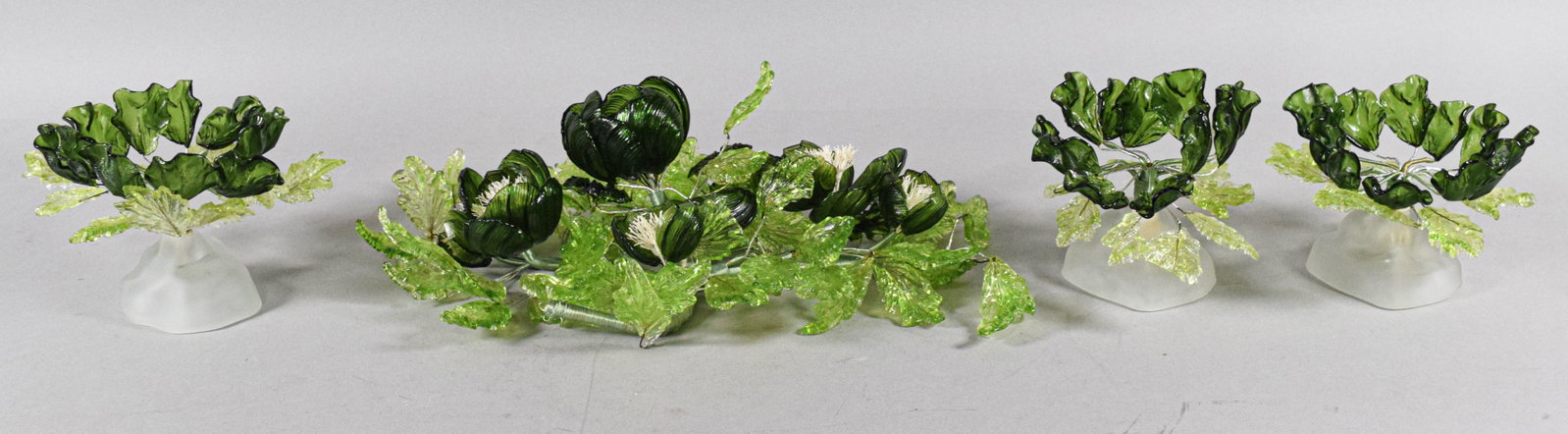 A 4-Piece Murano Style Lampworked Glass Floral Centerpiece Set: This decorative centerpiece ensemble comprises four pieces of glass floral work including a large horizontal spray and three smaller companion arrangements. The set is executed in a style evocative of