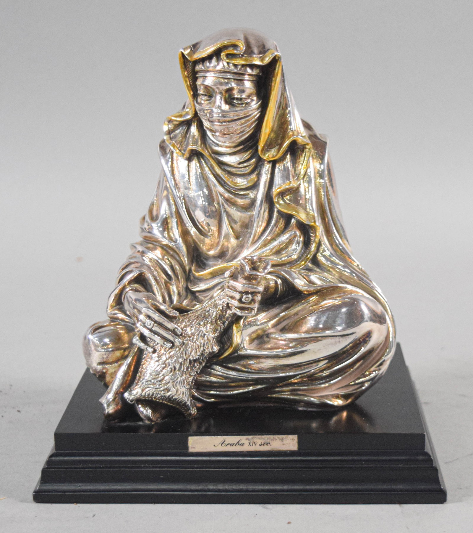 A. Giannelli for Magrino Silver-Clad Seated Arab Figure Sculpture, 1989: This lot features a silver-clad sculpture titled Araba XIV sec., created by the artist A. Giannelli for the Italian manufacturer Magrino. The piece is dated 1989 and depicts a seated figure in traditi
