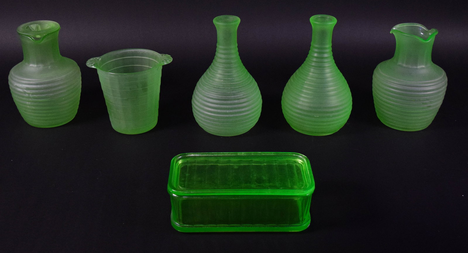 Group of 6 Frigidaire Uranium Glass Refrigerator Ware Items: This set consists of six pieces of green uranium glass, also known as Vaseline glass, produced as advertising premiums for Frigidaire. The items are designed in a beehive ribbed pattern. The collectio