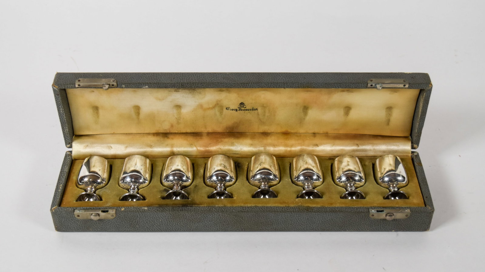 A Set of 8 Baldwin and Miller Sterling Silver Cordials in a Georg Jensen Case: A set of eight sterling silver cordials manufactured by Baldwin and Miller of Newark, New Jersey, and retailed by Georg Jensen Inc., New York. The underside of each bowl is stamped with the manufactur