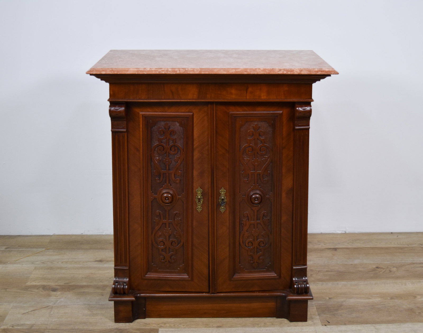 Renaissance Revival Walnut Buffet Cabinet with Marble Top: A walnut buffet cabinet in the Renaissance Revival style, dating to the late 19th or early 20th century. The piece features a rectangular pink and cream mottled marble top with a tiered, beveled edge.