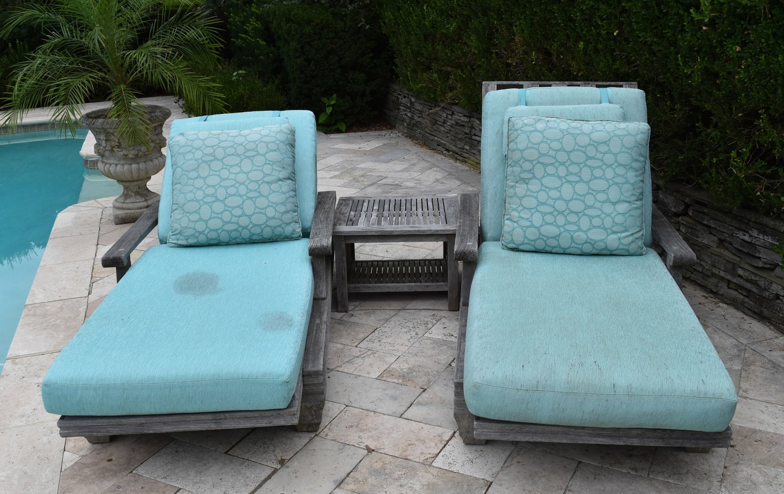 Pair of Giati Teak Chaise Loungers and Barlow Tyrie Mission Side Table: A suite of outdoor furniture comprising a pair of Giati reclining lounge chairs and a Barlow Tyrie Mission style side table. The lounge chairs are constructed from solid teak and feature wide armrests