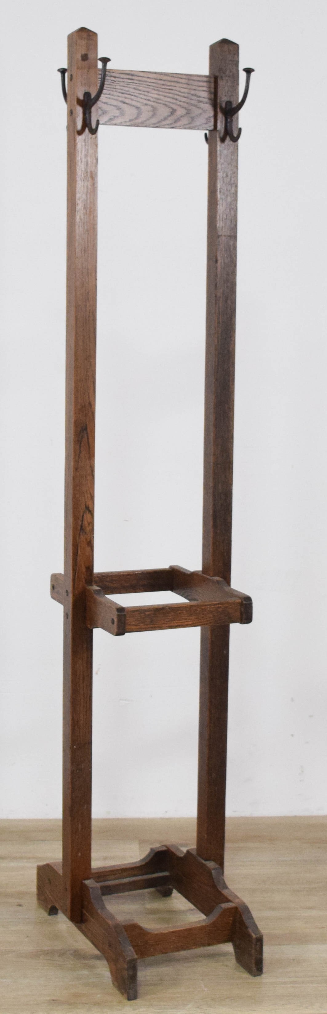 Arts and Crafts Oak Hall Stand: Arts and Crafts oak hall stand. The structure includes two tall square-profile upright posts connected by a wide horizontal top rail and an intermediate rectangular umbrella ring. Four sets of cast