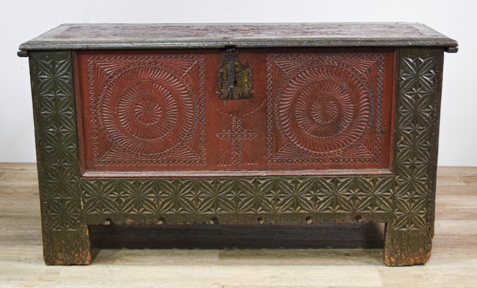 Early Chip Carved Polychrome Painted Wood Folk Art Dower Chest: Early chip-carved folk art dower chest. It is constructed of heavy wood planks with a traditional rectangular form. The exterior displays a polychrome painted surface in muted red and dark green tones