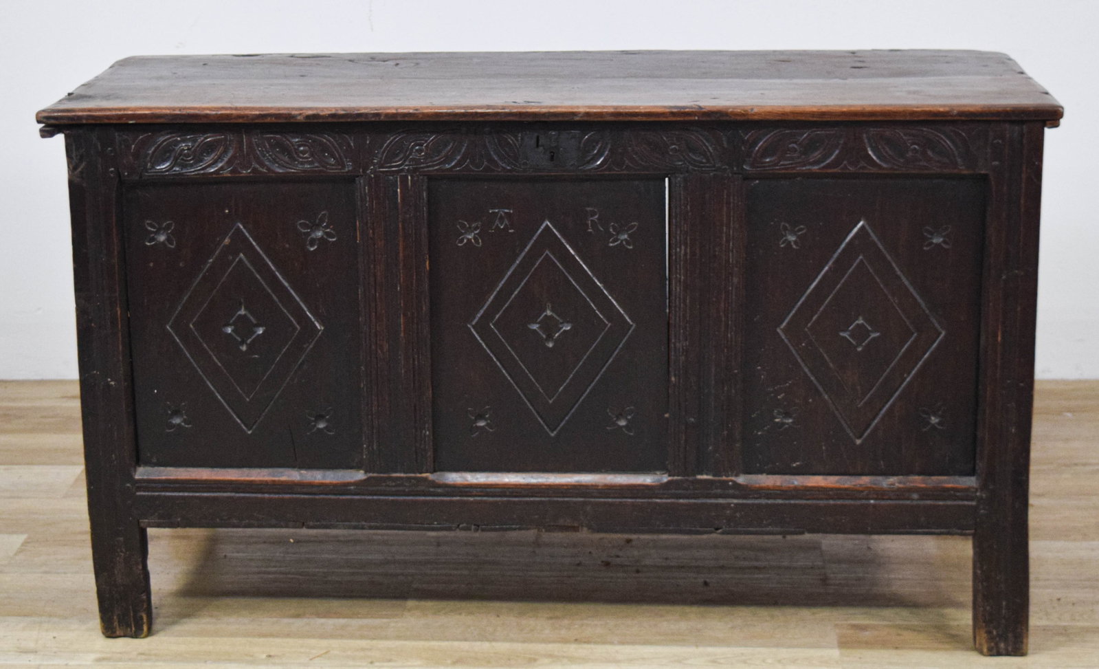 Jacobean Carved Oak Coffer: Jacobean joined oak three-panel coffer, late 17th or early 18th century. Constructed of dark-stained oak using mortise and tenon joints, the chest displays a frame-and-panel design. The interior retai