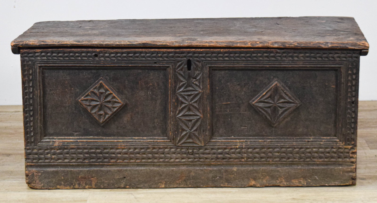 17th Century Carved Oak Blanket Chest With Bootjack Ends: 17th Century carved oak blanket chest or coffer constructed of wide oak planks with a dark-patinated finish. The primitive plank construction features a heavy, single-board lid with a molded front