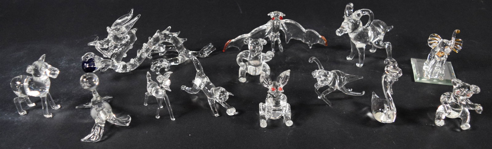 13 Hand-Blown Clear Glass Animal and Mythical Creature Figurines: Collection of 13 hand-blown clear glass figurines produced using lampworking techniques. The assortment includes a variety of animal and mythical subjects: a coiled oriental-style dragon holding a dar