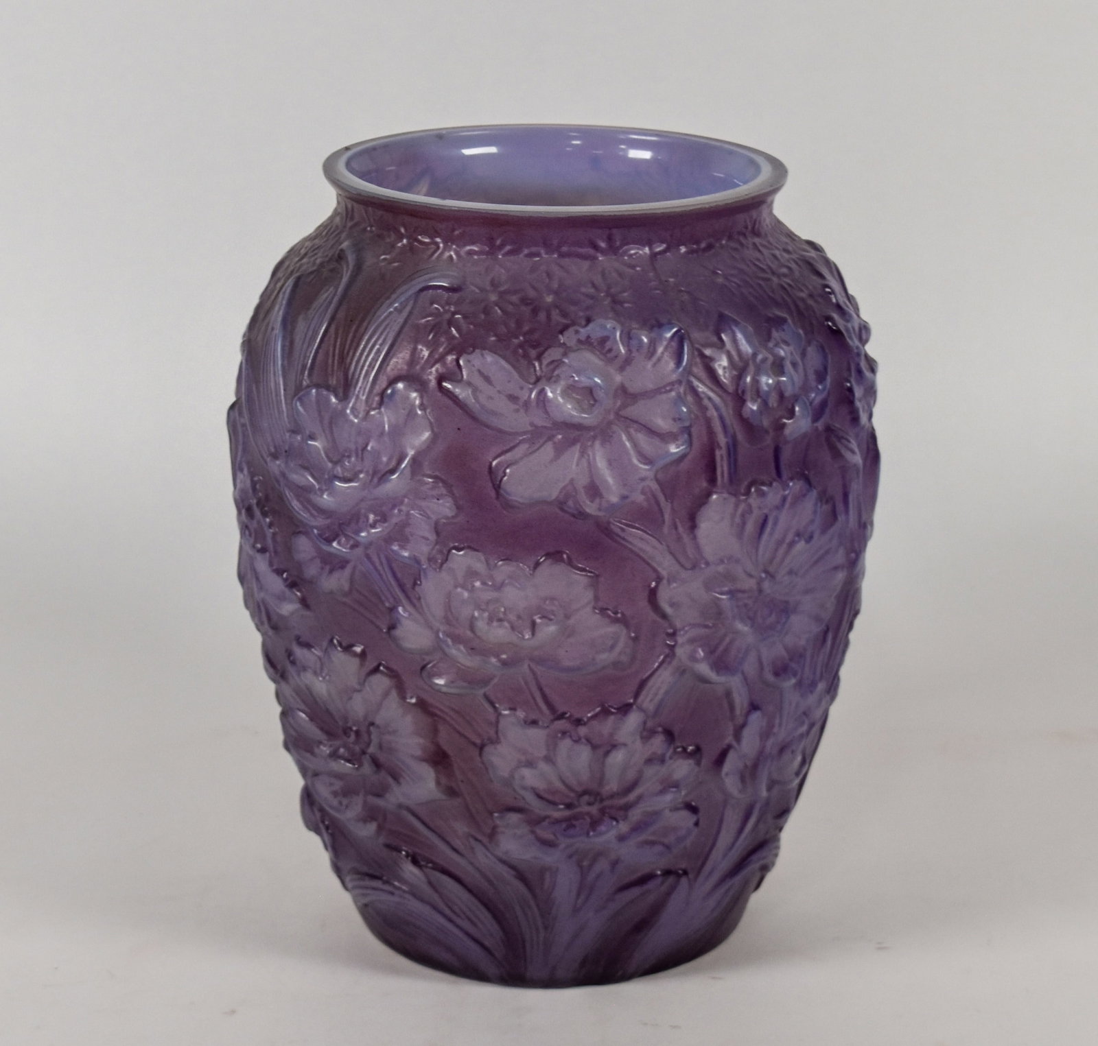 Phoenix Amethyst Opalescent Sculptured Glass Poppy Vase: Phoenix amethyst opalescent sculptured glass vase in the Poppies pattern. This mold-blown vessel features deep relief decoration with a high-relief floral pattern of poppies and smaller star-shaped bl