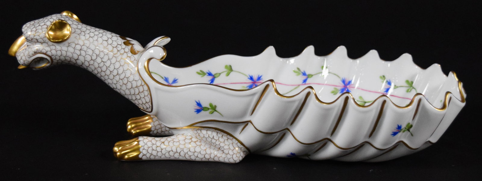 Herend Hand Painted Porcelain Dragon Shell Dish: A Herend hand painted porcelain dish in the form of a mythical dragon or chimera. The vessel features an elongated, scalloped, and ridged body in a shell form resting on two front legs with four gilde
