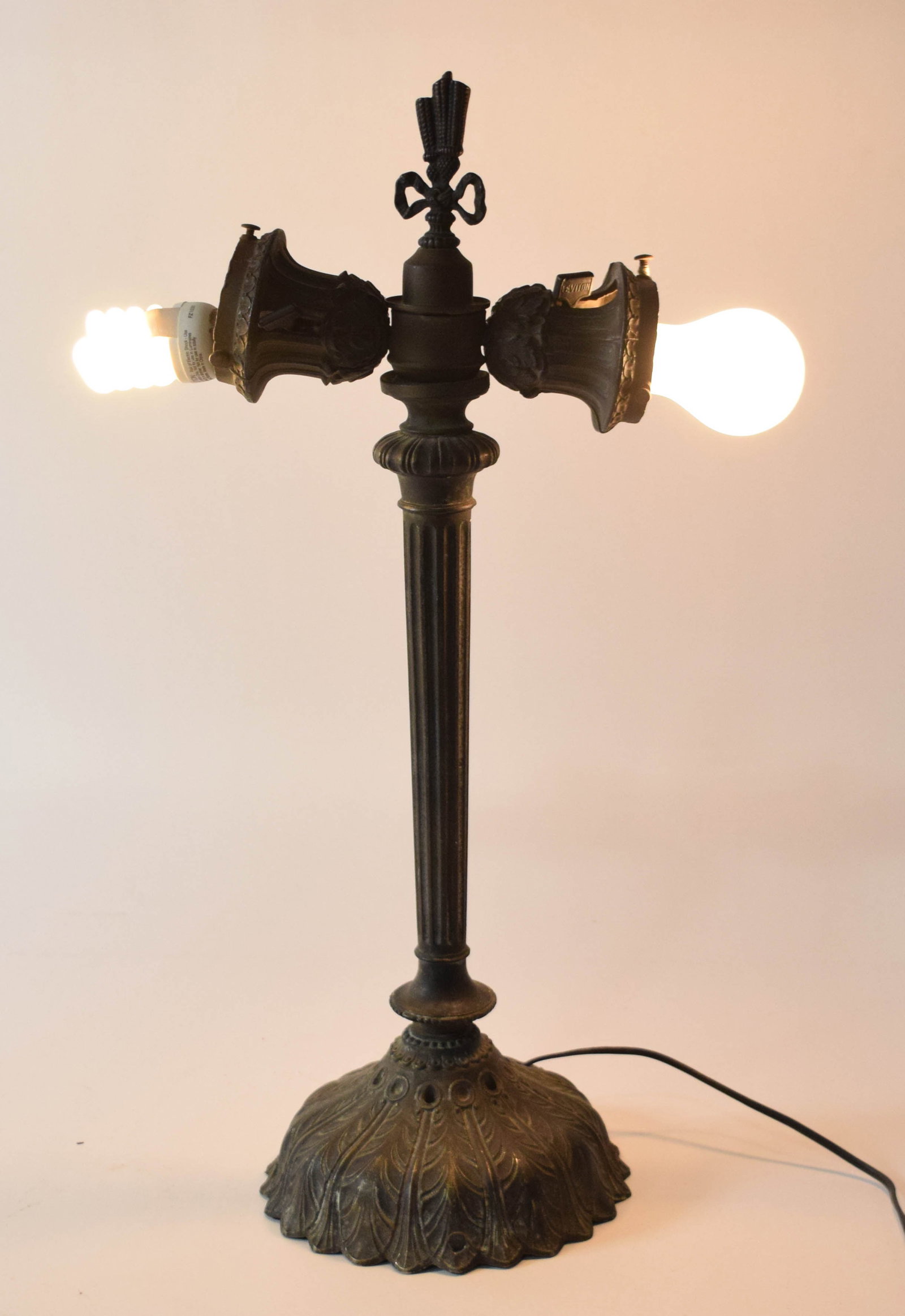 Classical Revival Style Fluted Cast Metal Double Socket Table Lamp Base: Classical Revival style table lamp base featuring a fluted central column and a domed foliate base. The structure is composed of cast white metal with an applied dark bronze-tone patinated finish. The