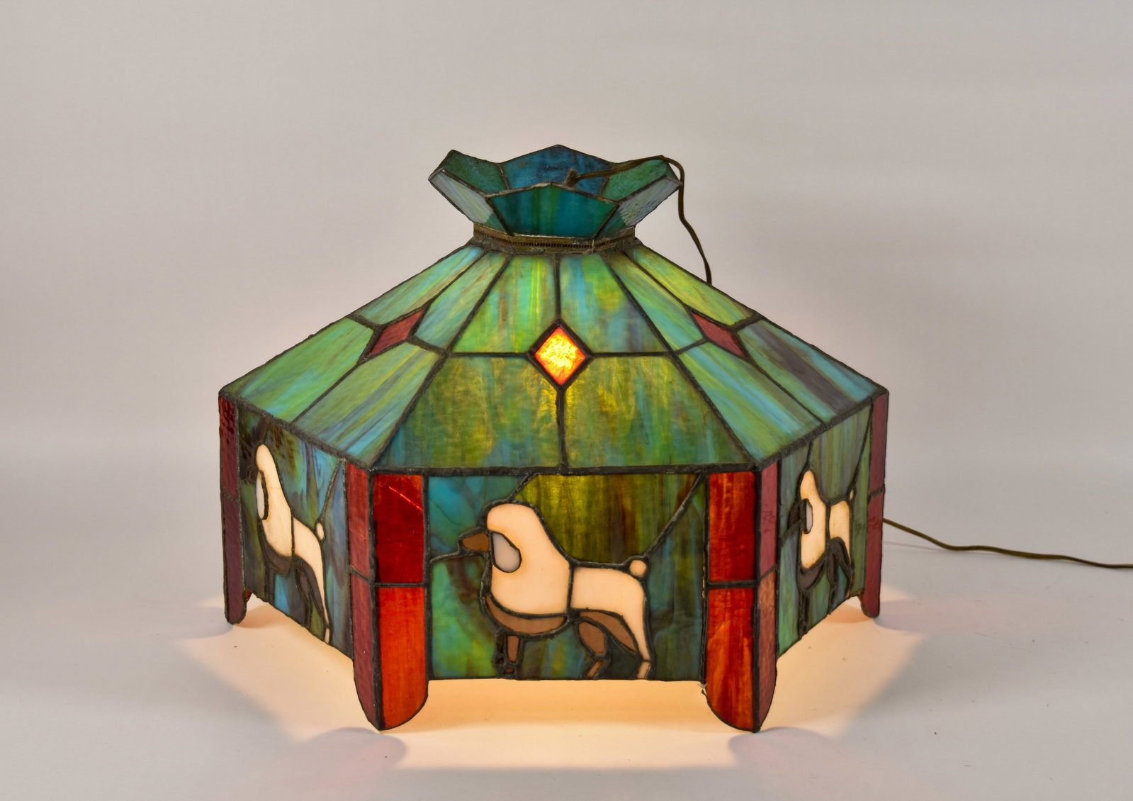 Stained Glass Hexagonal Poodle Motif Chandelier: Hexagonal stained glass chandelier featuring a novelty poodle motif. The fixture is constructed with leaded glass panels in a variety of opalescent and slag glass colors. The six-sided shade displays 