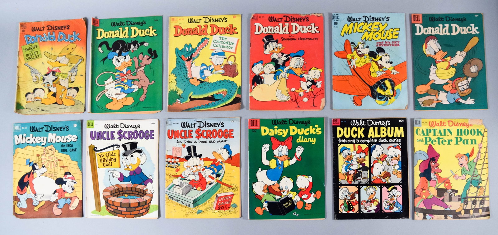 12 Dell Walt Disney Comic Books Featuring Donald Duck and Uncle Scrooge: Dell Walt Disney vintage comic books, mid-20th century, newsprint and paper. This group includes 12 softcover newsprint booklets published between 1944 and 1954 featuring various characters including 
