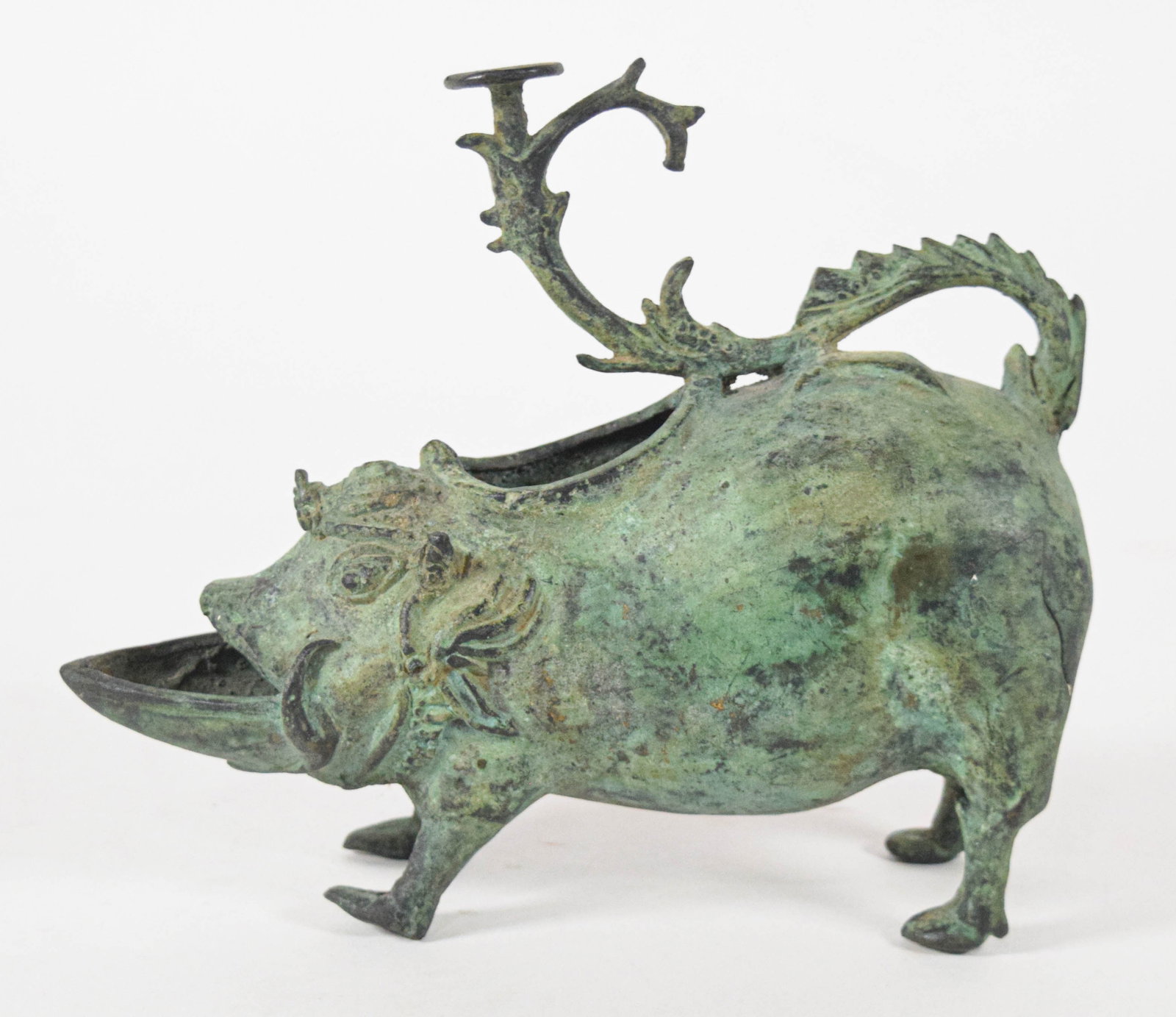 Archaic Style Cast Brass Boar Oil Lamp: Archaic style zoomorphic oil lamp in the form of a standing boar, constructed of cast brass with a heavy verdigris patina. The stylized boar features a mouth agape to serve as a wick trough. A decorat
