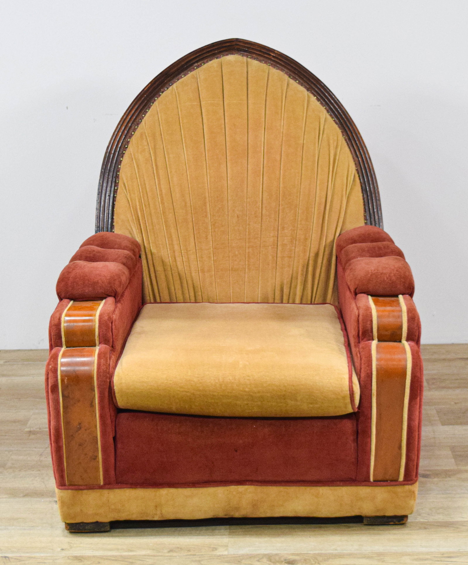 Art Deco Velvet Armchair with Burl Wood Accents: Art Deco armchair with a two-tone velvet upholstery scheme. The high, peaked back displays a radiating sunburst pattern stitched into mustard yellow velvet. The chair frame is constructed from dark-st