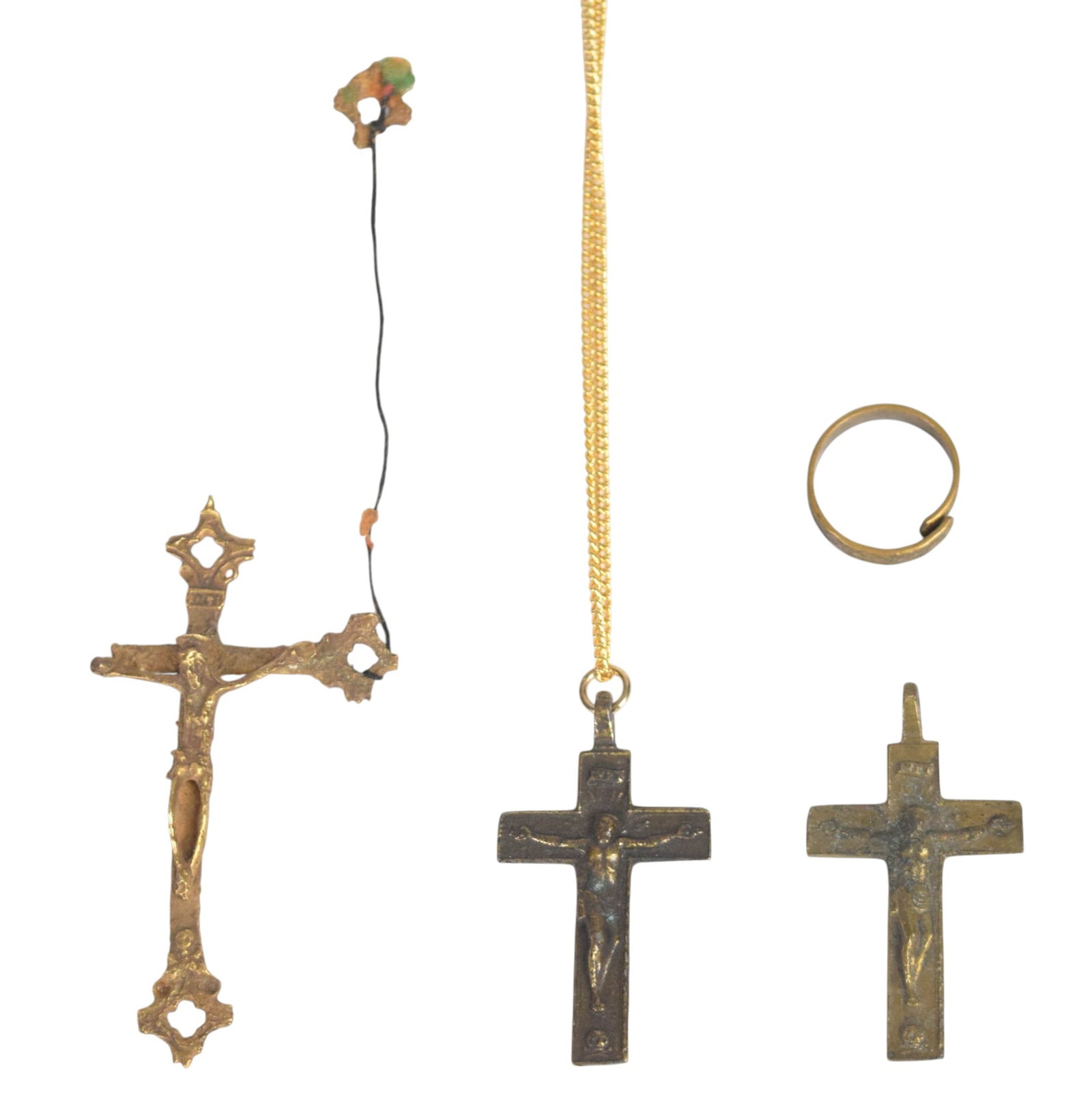 4 Brass and Bronze Religious Items Including 3 Crucifix Pendants and 1 Ring: Group of four religious items consisting of three crucifix pendants and one adjustable band ring. The pieces are constructed of cast brass and bronze with varying degrees of gold plating. The largest 