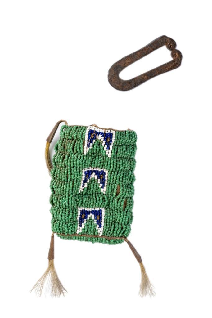 Plains Beaded Hide Strike-a-Light Bag, with Striker: 2.5" x 3.75". Reservation period, Bead stitched hide, adorned with tin cones and hair tassels. **Good condition overall with some pulling of stitching and beadwork. One tin cone has detached but is in