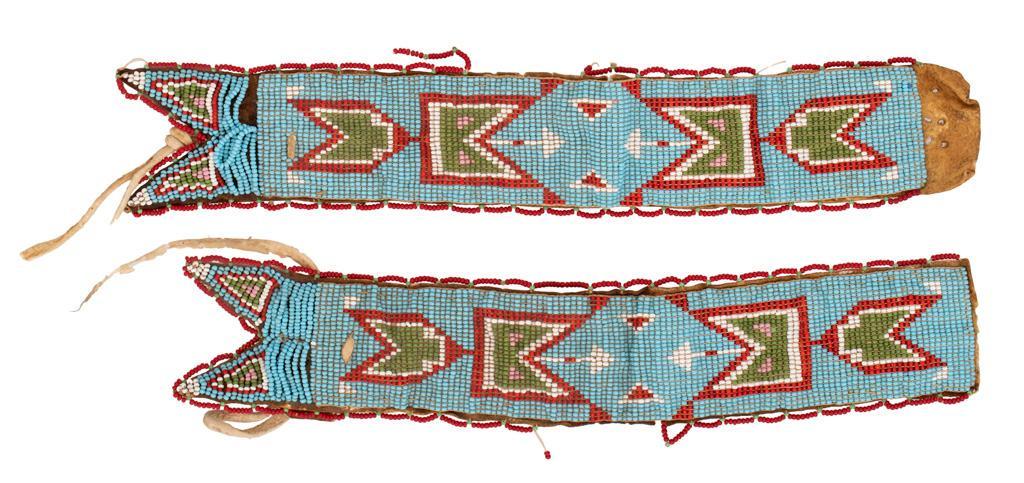Pair of Plains Beaded Armbands: 11.25" x 2". Buckskin armbands beaded throughout with light blue, red, white, green, and pink beads featuring a red and light green border. **Good condition overall. Some stiffening of buckskin with s