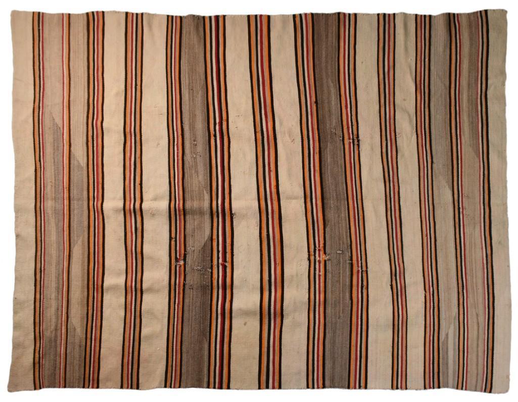 Navajo Blanket: 62.5" x 78.5". Polychrome stripes with visible lazy lines. **Good condition overall. Some scattered moth holes and loosening of fibers to edges.** $400-$600