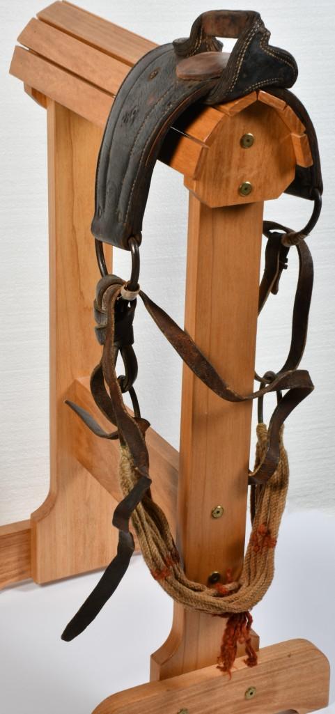 Jim Houston Bareback "Bronc" Saddle: Leather construction with correct hard handhold. Woven cincha strap. Leather shows Jim Houston stamp. Stand not included. **Good condition overall. Some darkening of leather, which shows some dryness.