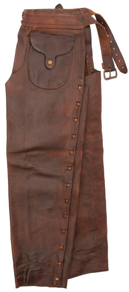 Pair of Leather "Shotgun" Chaps Attributed to Bill Pickett: 39" overall length. Tooled waistband with brass snap buttons on two exterior pockets. Shows maker's mark of T. Flynn. Flynn operated in Pueblo, Colorado between 1892-1935. Provenance Miller Brothers (