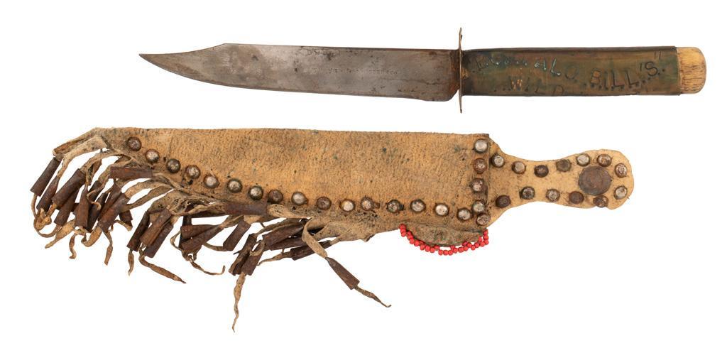 Souvenir Knife from Buffalo Bill's Wild West Show: 4.5" clip-point blade with 1.25" false edge. Thin brass crossguard with bone handle wrapped in sheet of brass stamped "BUFFALO BILL'S/WILD/WEST". Buckskin sheath with tacks and tin cones. Blade marked