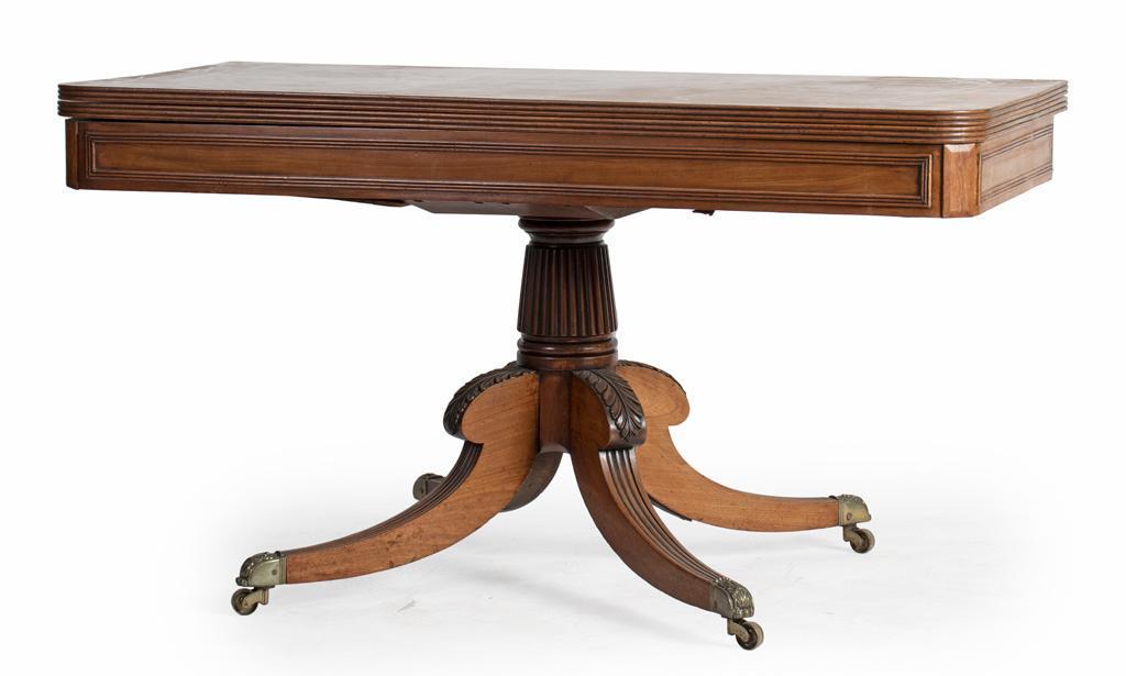 An English Duncan Phyfe Breakfast Table: English, 19th century. Duncan Phyfe breakfast table in mahogany, having a reeded rectangular fold out surface with mirrored case above the vertically reeded standard, rising on carved acanthus leafed