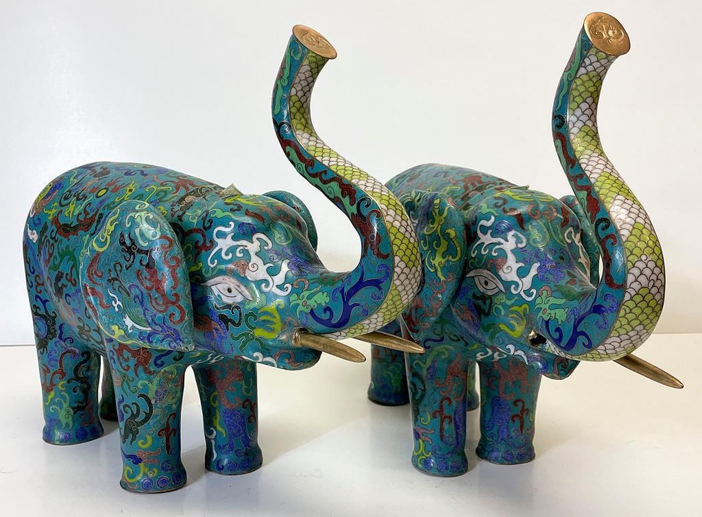 A Pair of Chinese Cloisonne Elephants: Chinese, 20th century. A pair of Chinese cloisonne elephants, each having elaborate foliate motif throughout; ht. 12, wd. 17, dp. 6 inches. Overall good condition. Single elephant with broken tusk tha