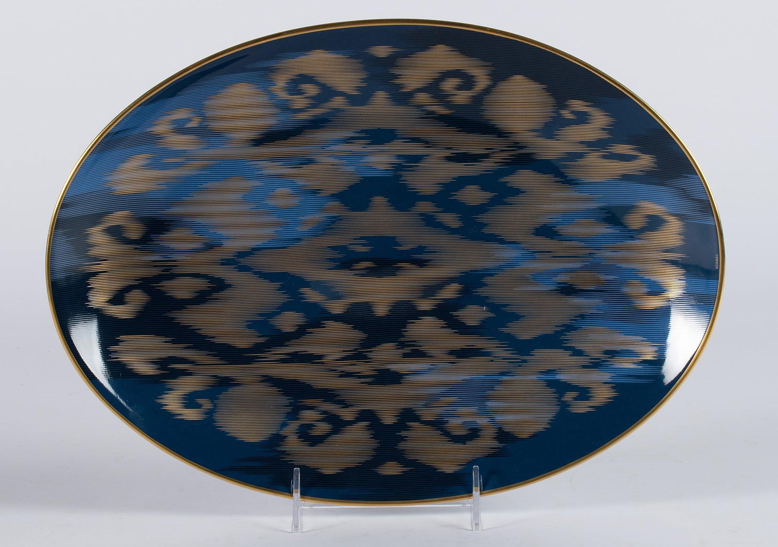 Hermes Voyage en Ikat Sapphire Oval Platter: French, 21st century. An oval porcelain platter by Hermes in the Voyage en Ikat pattern; 14 x 10.25 inches. Overall in very good condition. In original box, hallmark on underside.