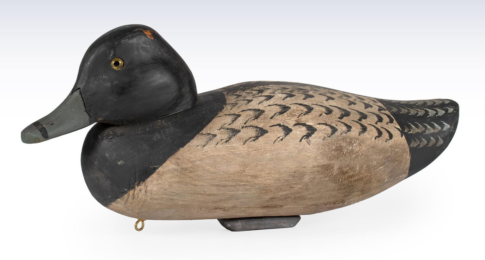 Antique Hand Carved and Painted Black and White Duck Decoy: American, 20th century. A hand carved and painted black and white duck decoy with yellow glass eyes and lead weight; ht. 6, wd. 13, dp. 6 inches. Overall good condition.