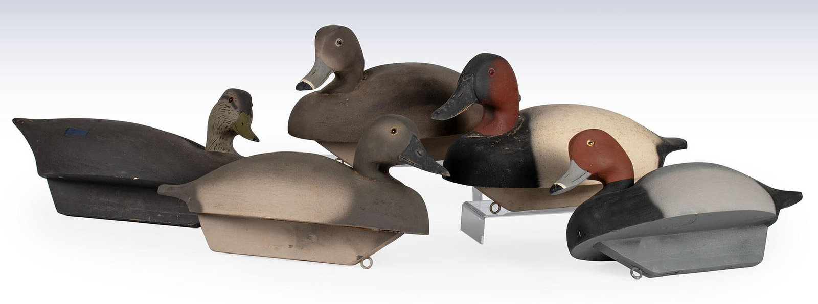 A Group of 5 Wildfowler Decoys Inc. Quoque New York Painted Decoys: American, 20th century. A group of 5 various sized and species carved and painted duck decoys, each marked Wildfowler Decoys Inc. Quoque New York.; largest ht. 7, wd. 15, dp. 6.5 inches. Overall good 