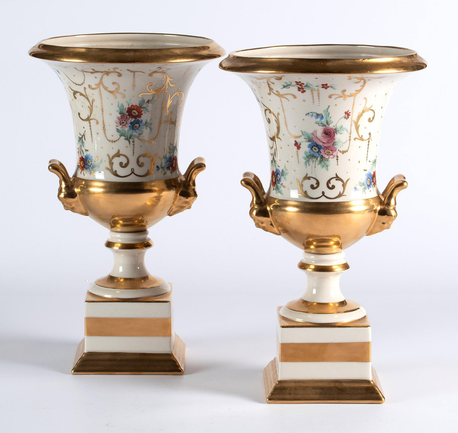 A Pair of Continental Porcelain Planters: Continental, 19th century. A pair of Continental porcelain planters, each with gold trim highlights and overall foliate decoration, urn shaped body with handles, rising on molded base; ht. 13.5, dia. 