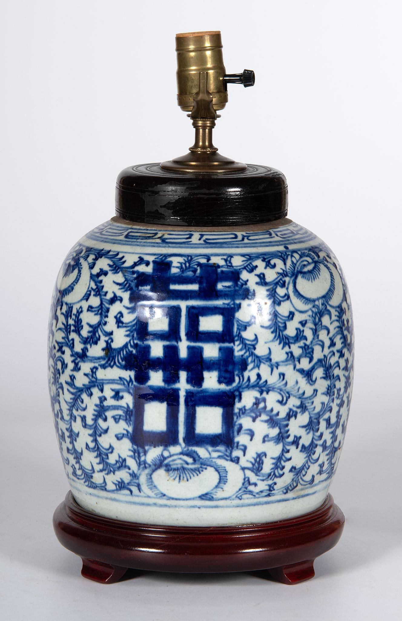 Chinese Blue and White Double Happiness Covered Ginger Jar: Chinese, 19th century. A Chinese cobalt decorated blue and white double happiness ginger jar, wooded lid, rising on carved stand, electrified; ht. 15 x dia. 8 inches (with stand and harp). Overall go