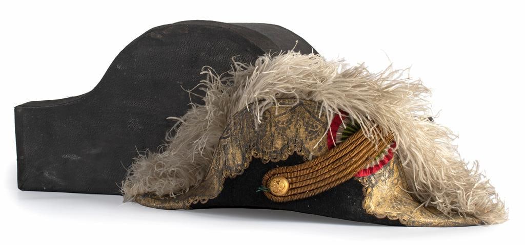 Cased Chapeau Attributed to Don Porfirio Diaz: Constructed of black beaver felt with white ostrich feathers. This Chapeau features heavily gilded in gold braid and bullion, Gold Mexican officers button with eagle & snake motif, a (red, white, and