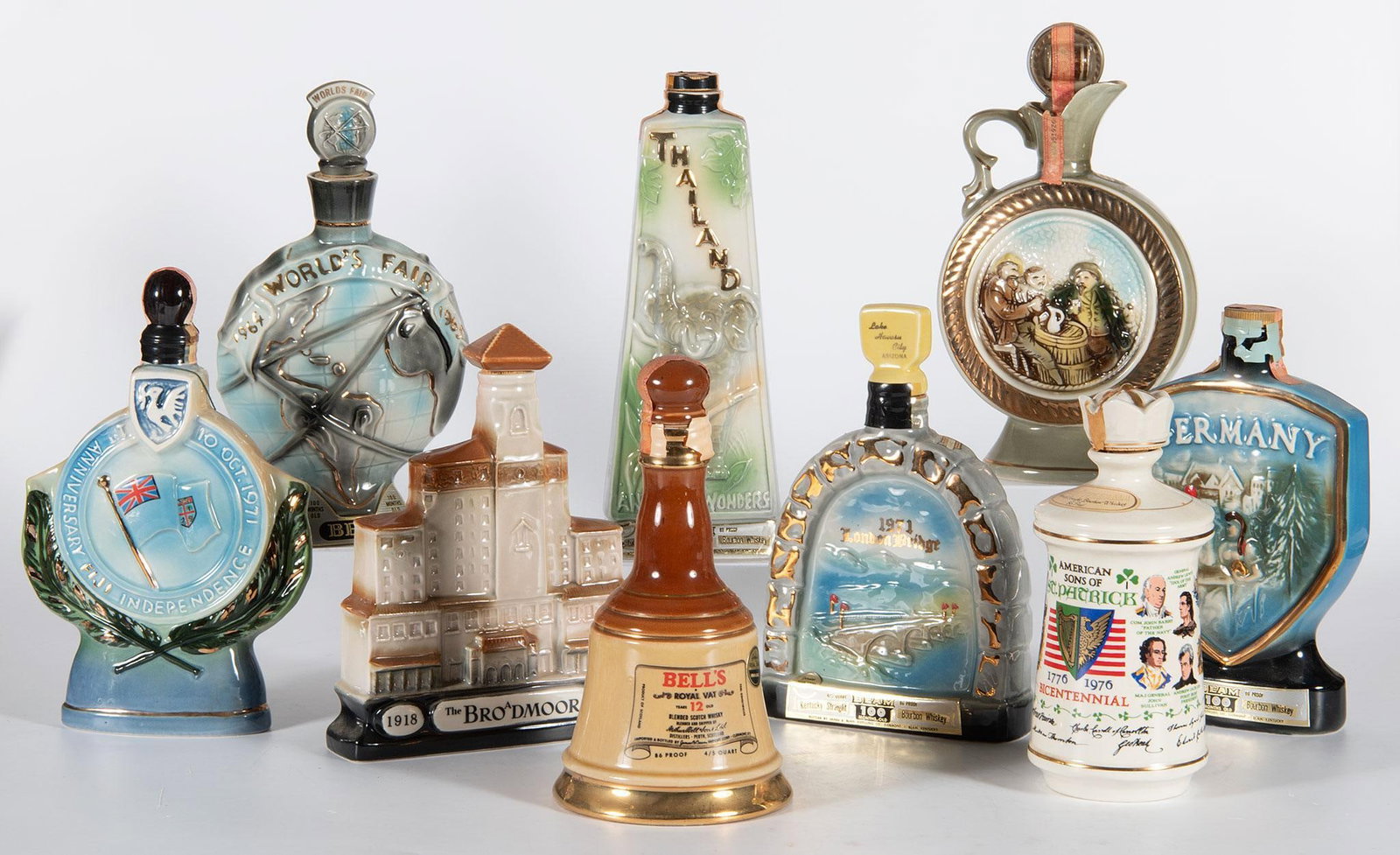 Vintage Jim Beam Continental Related Porcelain Decanters: Lot consists of 9 vintage Jim Beam porcelain decanters, including Bells Royal Vat, Old Fitzgerald American Sons of St. Patrick, Anniversary of Fiji Independence, 1971 London Bridge, Germany, Thailand,