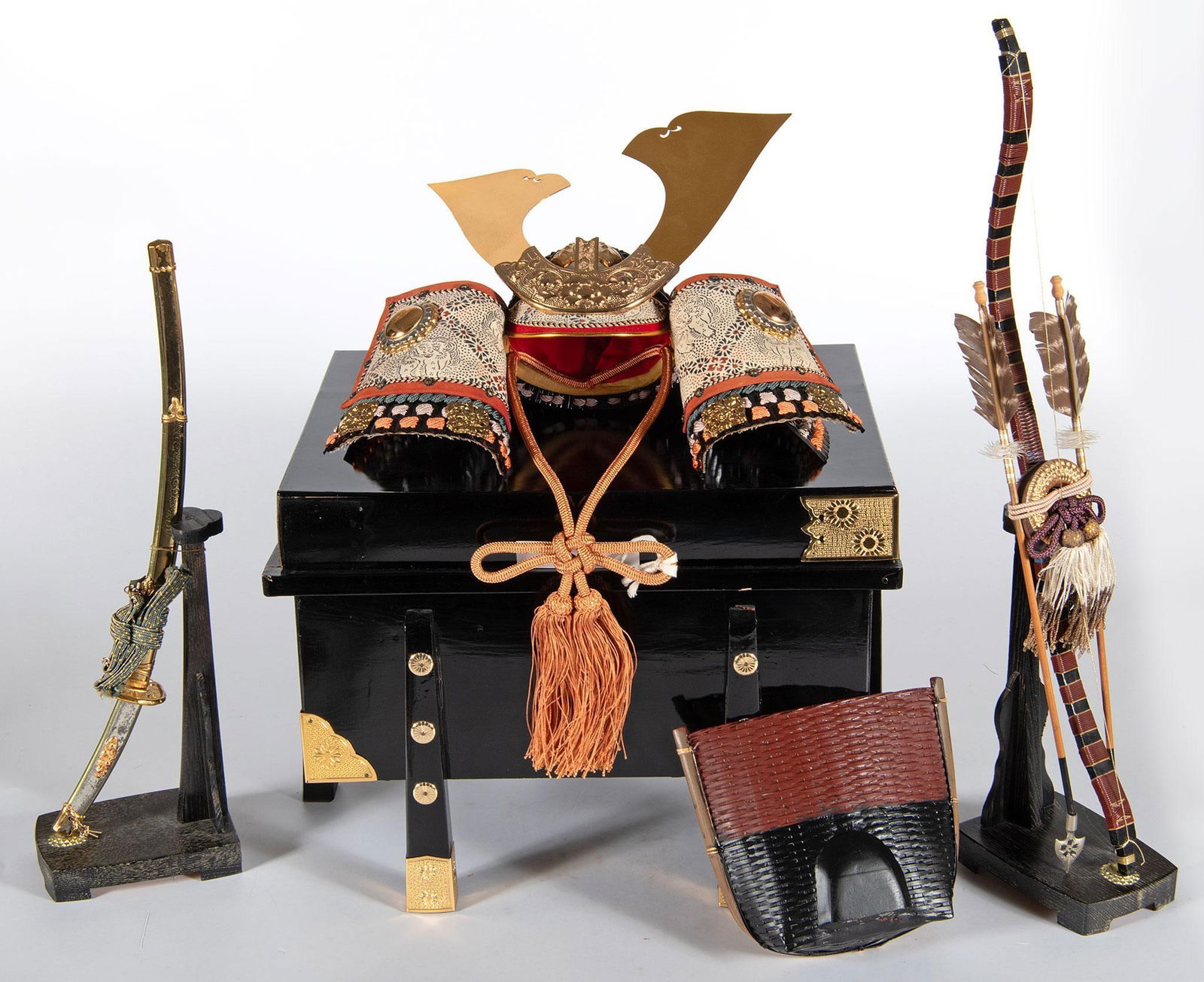 Japanese "Boys Day" Kabuto Helmet Plus: Japanese, 20th century. A Japanese "Boys Day" Kabuto helmet with display box, Katana and Bow set, The boy wears this helmet while riding on the back of a carp that swims up-stream and at the end of th