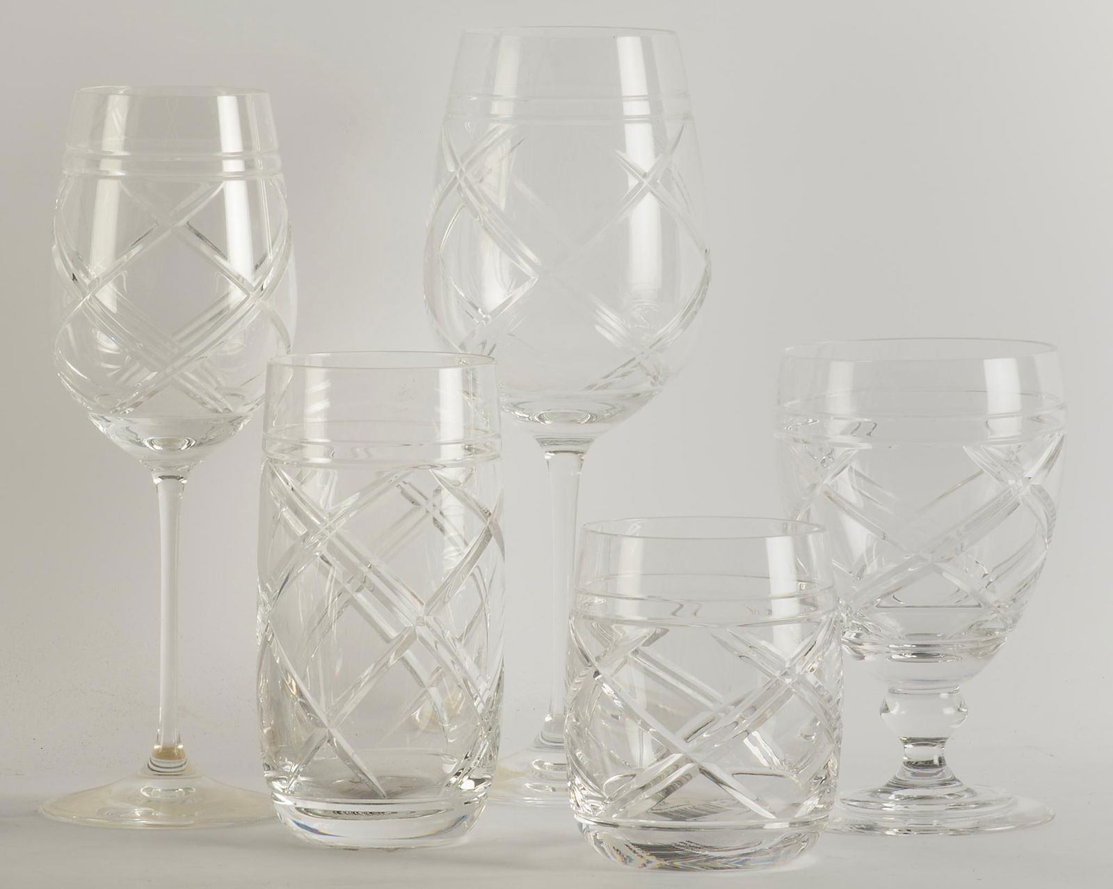 Ralph Lauren Brogan Pattern Stemware Pieces: Set of twenty one Ralph Lauren "Brogan" pattern crystal stemware, includes eight highball glasses, eight red wine glasses, , two tumblers, a single water glass, and two other wine stems all marked "Ra