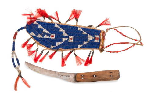 Native American Plains Beaded Knife Sheath: A Native American plains beaded knife sheath, having overall beadwork and painted parfleche measuring 8" x 2.75". bead decorated on one side with white and red-heart geometric patterns on a blue backg