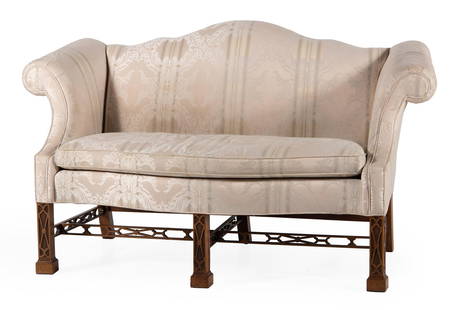 Chinese Chippendale Style Sofa by Baker Furniture: American, 20th century. A Chinese Chippendale style upholstered camelback sofa by Baker Furniture, having a shaped crest and open arms, rising on Chinese Chippendale style straight square carved legs