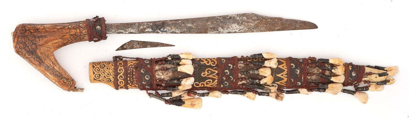 African Dyak Mandau Headhunters Sword: African, 20th century. A Dyak Mandau steel sword with painted bone hilt and wooden scabbard decorated with bones; 14 inch blade, overall 25 inches. Overall good condition. Rust to the steel blade.