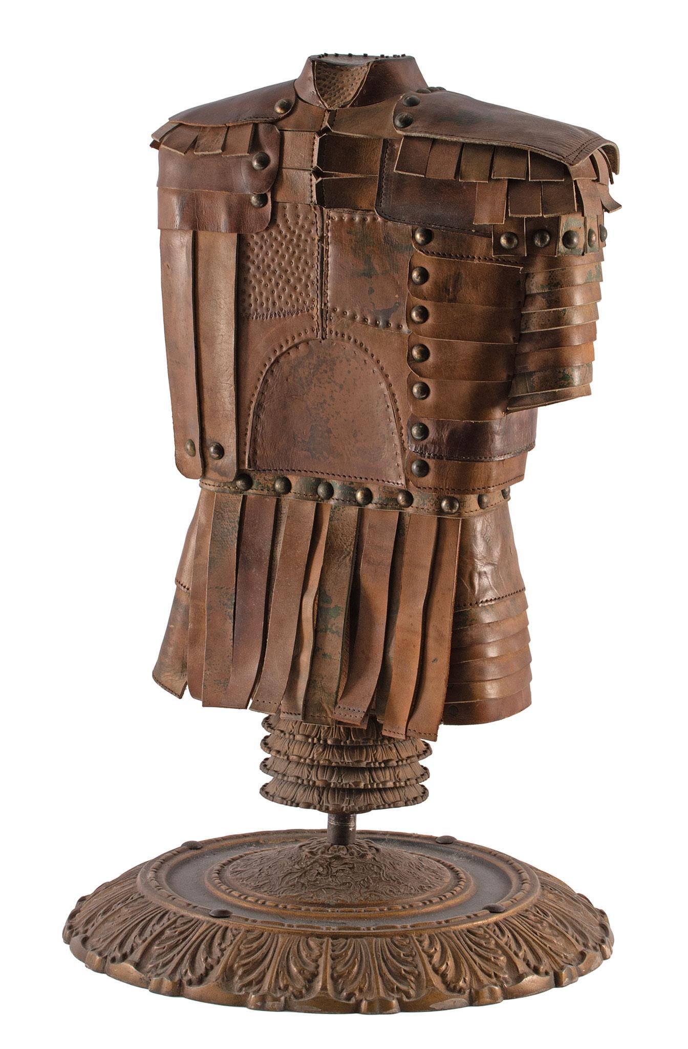Miniature Half Suit Of Armor by Don Coppock: Leather Mounted on a stand with a floral meatal base. The base is 14.5" in diameter, and 22" high. Excellent condition.