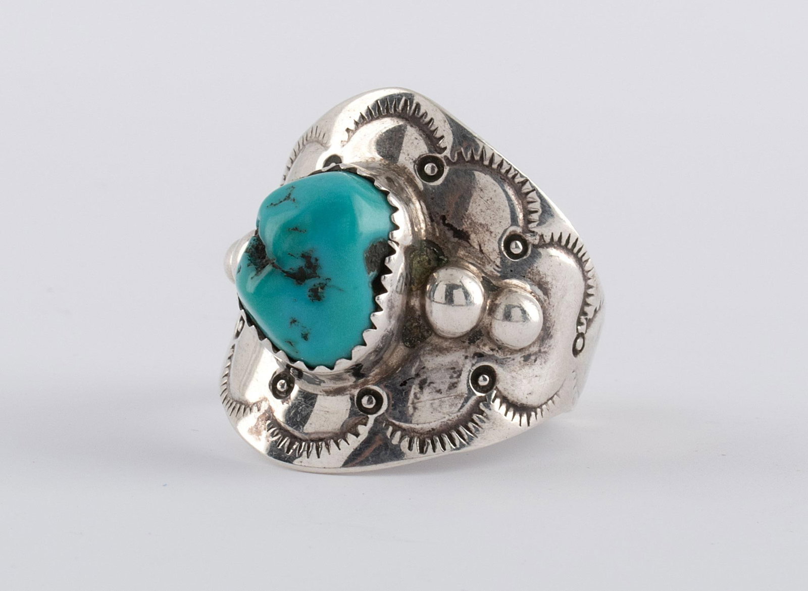 Navajo Sterling Silver and Turquoise Ring: Native American, 20th century. A single Navajo sterling ring with central turquoise stone and etched design throughout, hallmarked "GR". Overall good condition.