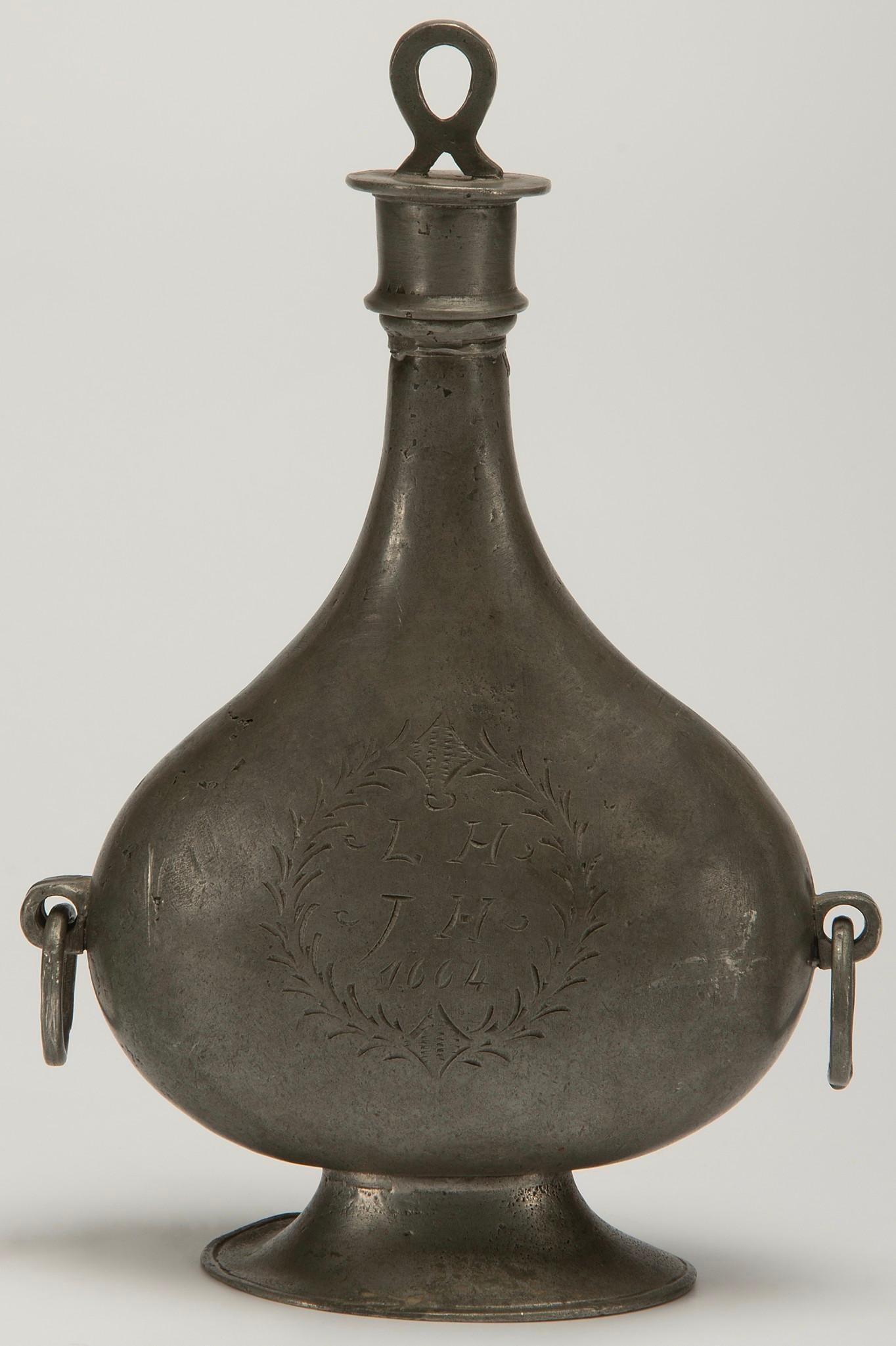 Early Pewter Wedding Decanter Dated 1664: A dated pewter decanter or flask with L.H. over J.H. initials and date of 1664 flaked by festoon decoration, hallmarks to base 95% pewter; ht. 10.5, wd. 7, dp. 3 inches.