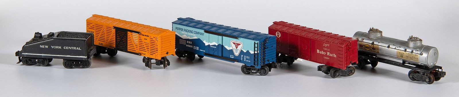 Grouping of Various Made Toy Trains: American, 20th century. Lot includes 5 toy train cars of 2 KLine Pepper Packing Company and Rio Grande, a Lionel Baby Ruth Candy, MAR New York Central, and a Lionel Sunoco Gas Car. Overall good fair t