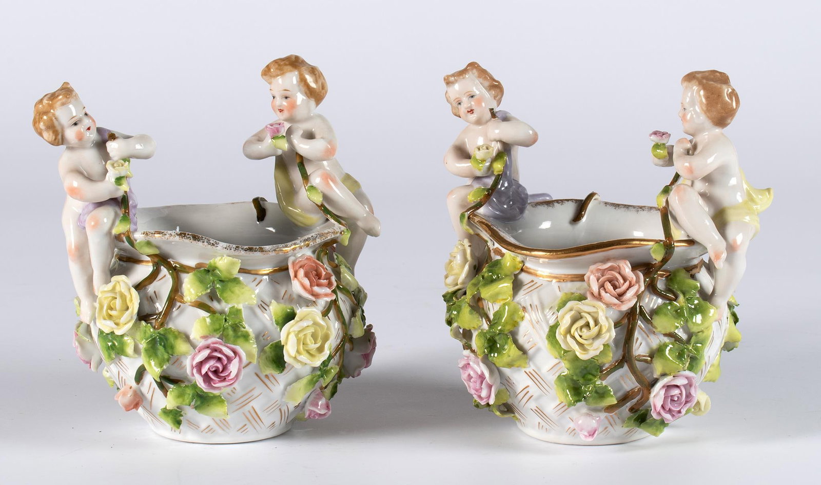 A Pair of German Porcelain Bowls: German, 19th century. A pair of German porcelain bowls with overall rose design with cherub handles; ht. 5.5, wd. 5, dp. 5 inches. Overall good condition.