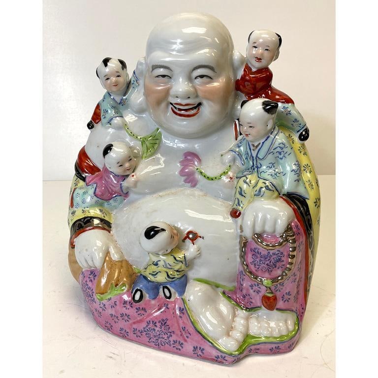 A Chinese Porcelain Buddha with Children: Chinese, 20th century. A Chinese porcelain buddha with polychrome decoration and shou symbols throughout robe; ht. 12, wd. 10, dp. 7 inches. Overall good condition.
