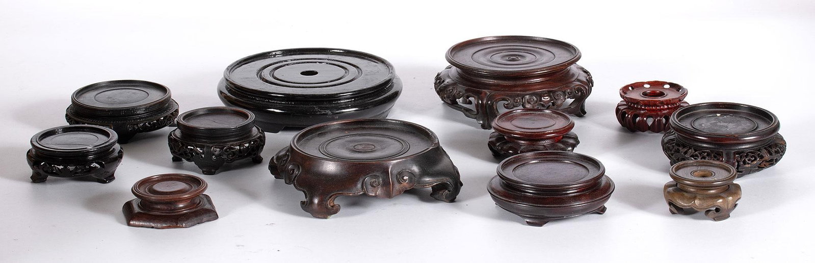Grouping of Chinese Rosewood Stands: Chinese, 20th century. A grouping of 12 various sized and wood stands for porcelain vases; largest stand diameter 6 inches. Overall good condition.