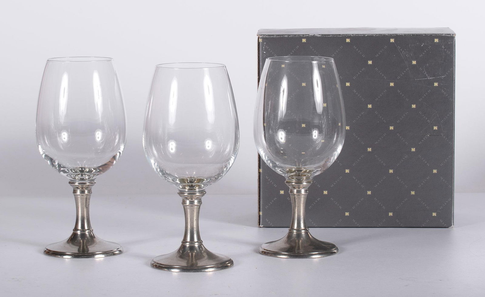 Italian Water Glasses by Match Pewter: Lot consists of 8 glass and pewter bases water glasses by Italian Match Pewter; ht. 7.75 x dia. 3.25 inches. Overall good condition. 6 of the glasses in original boxes.