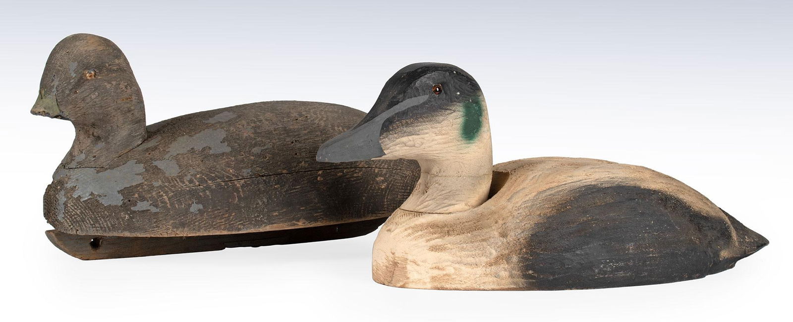 Two Paint Decorated Decoys: American, 20th century. Two carved and painted duck decoys, single with glass eyes; largest ht. 7, wd. 17, dp. 7 inches. Overall good condition. Single duck missing bill.